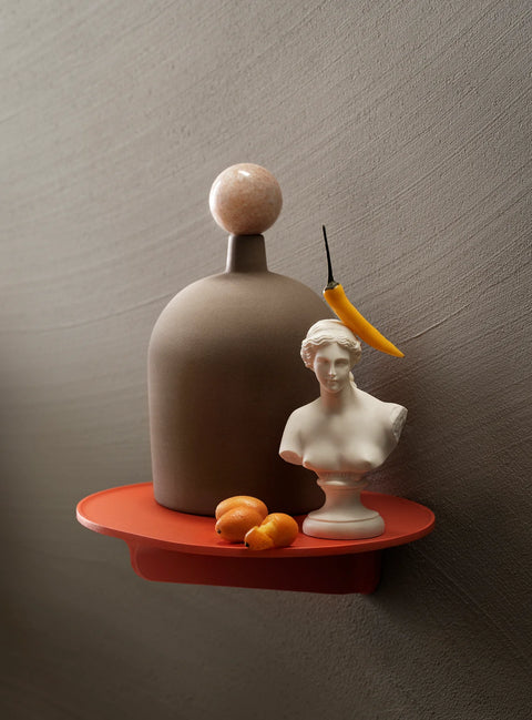 Museum NM&.045 shelf by String™ in orange styled with sculptural vase, marble sphere, white bust, chili pepper, and kumquats