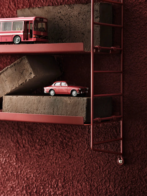 String® Pocket Metal shelf in red, styled with miniatures, Scandinavian modular shelving system.