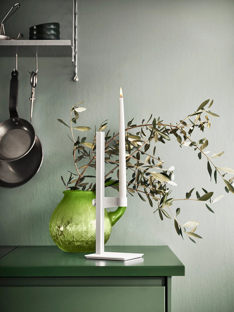 White Museum Candle Holder on green cabinet with olive branches in background, styled with Scandinavian kitchen décor.