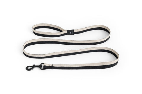 HAY Dog Leash Flat, Black and White, M/L, flat woven webbing dog leash, coiled with a black snap hook on a plain white background