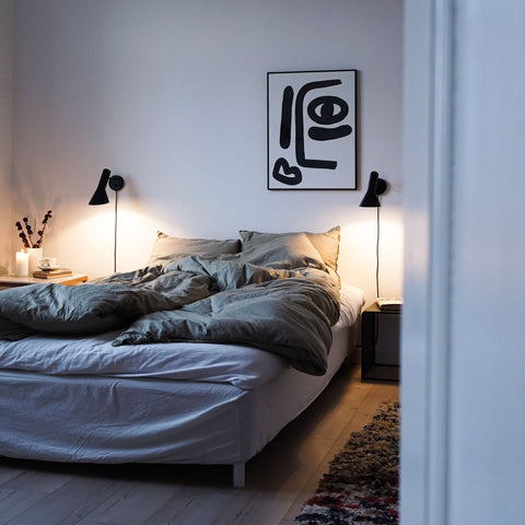 scandinavian bedroom with black aj wall lamps above nightstands