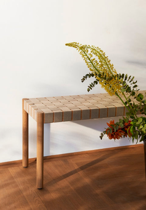 Oak Betty TK4 Bench by &Tradition with natural linen seat webbing beside floral arrangement