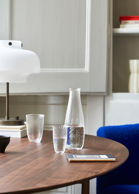 Detail of Drop Leaf HM6 table in walnut by &Tradition with glassware and white table lamp