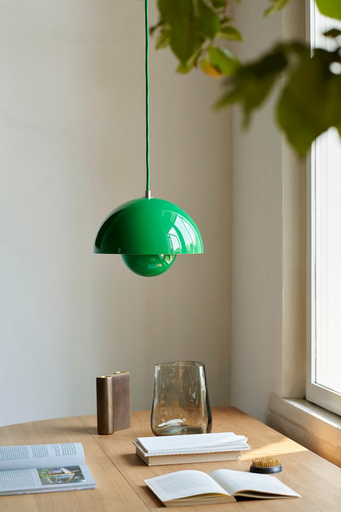 Flowerpot VP1 Pendant Light by &Tradition in Signal Green illuminating a wooden dining table with Collect Candleholder and Crafted Glass Vase.