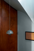 Flowerpot VP1 Pendant Light by &Tradition in Stone Blue hanging in a modern hallway with wood wall paneling.