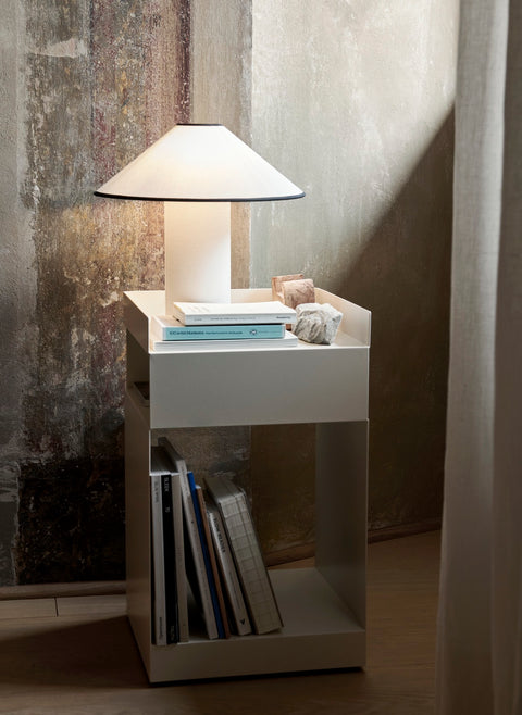 Rotate SC73 in ivory by &Tradition styled as a bedside table with lamp and books