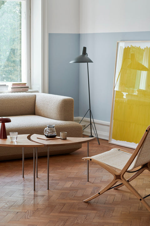 Light-filled living room with &Tradition Pinwheel HM7 End Tables in oak and stainless steel beside Develius sofa and Wulff chair