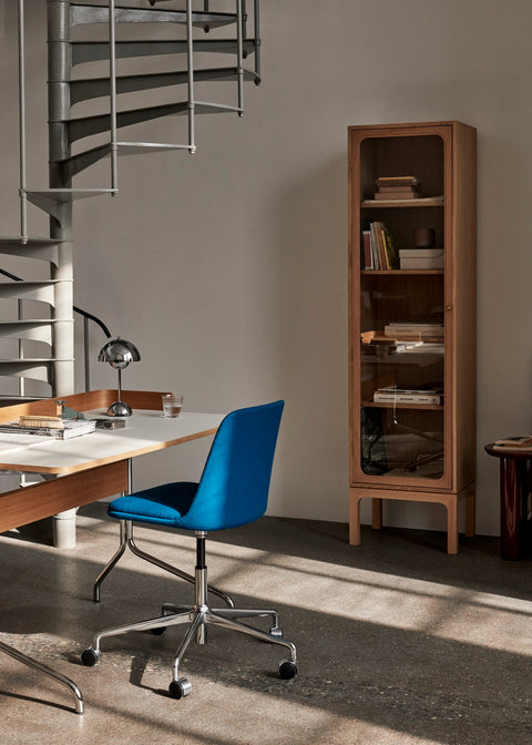 Scandinavian home office featuring the Trace SC87 Cabinet by &Tradition in natural oak next to a blue Rely chair and spiral staircase.