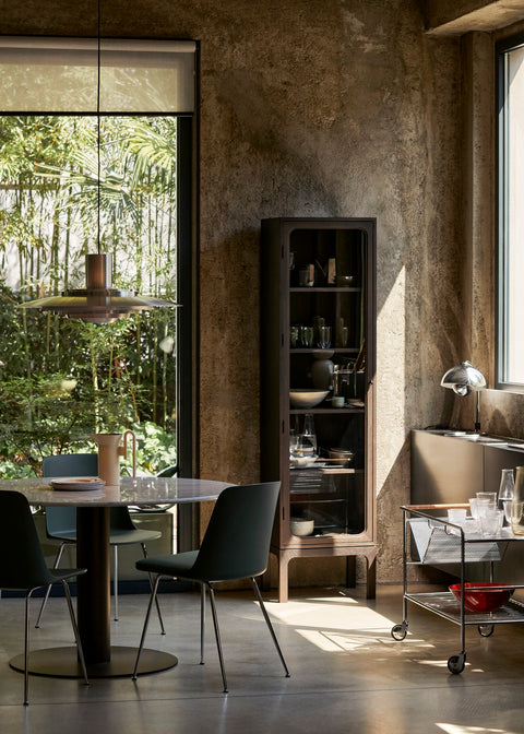 Scandinavian dining room with the Trace SC87 Cabinet by &Tradition in dark oak beside a round marble table and Flowerpot pendant light.