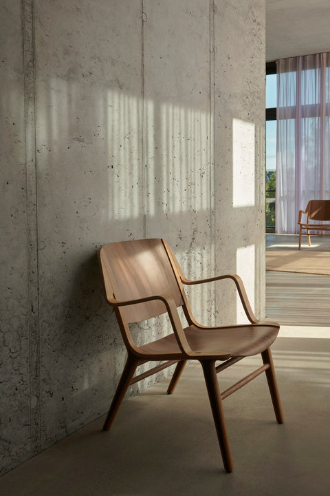 AX HM11 Lounge Chair by &Tradition positioned by large windows in Scandinavian-inspired living room