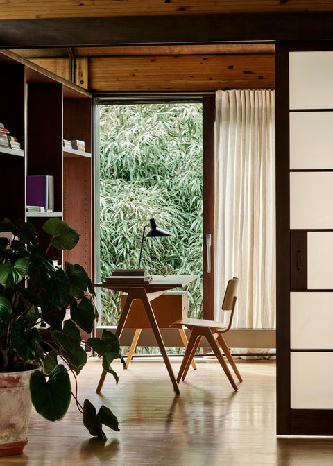 Scandinavian workspace with the Daystak RD3 Desk and Daystak Side Chair RD1 by &Tradition beside lush greenery and natural light.