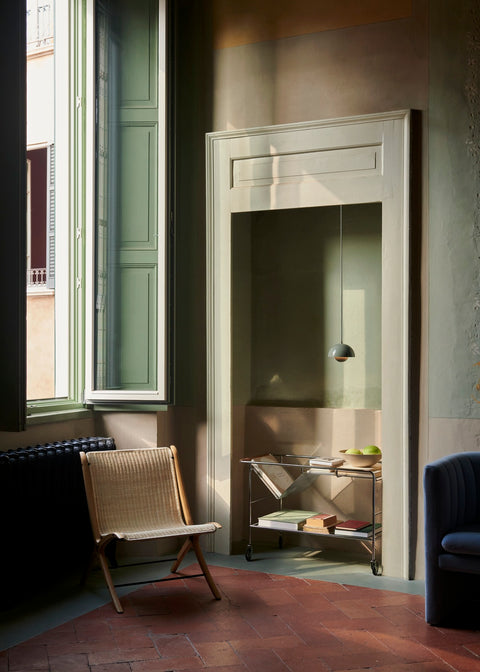 X HM10 Chair by &Tradition next to Alima ND1 trolley under a Flowerpot VP10 pendant in a sunlit room with green window trim