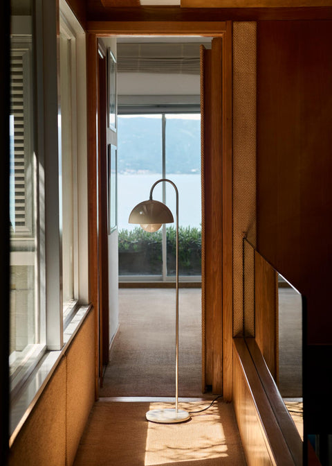 &Tradition Flowerpot VP12 Floor Lamp in Grey Beige illuminating a serene hallway with natural light and wood finishes.