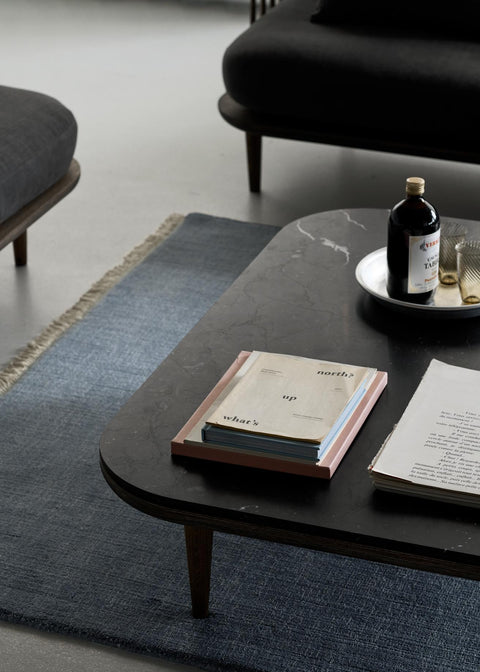 Detail view of Fly SC11 Coffee Table by &Tradition in smoked oiled oak with Nero Marquina marble top, styled with glassware and design books.