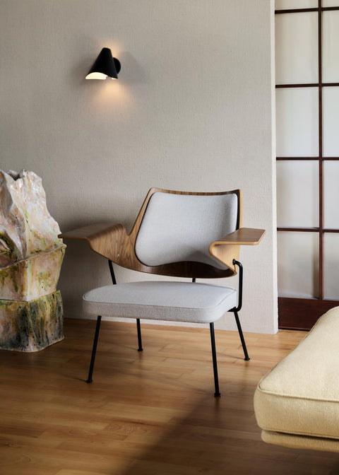 RFH RD8 Lounge Chair in light wood interior with black wall sconce and neutral furnishings