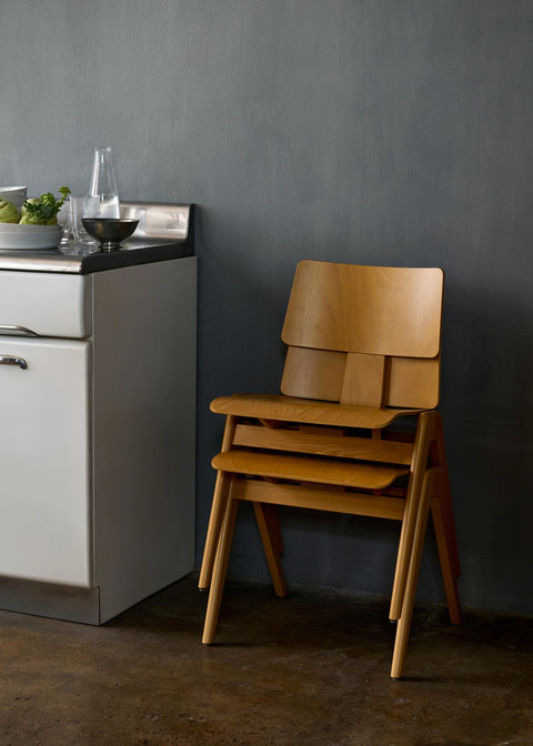 Stacked Daystak RD1 Side Chairs by &Tradition in beech placed in a modern kitchen setting