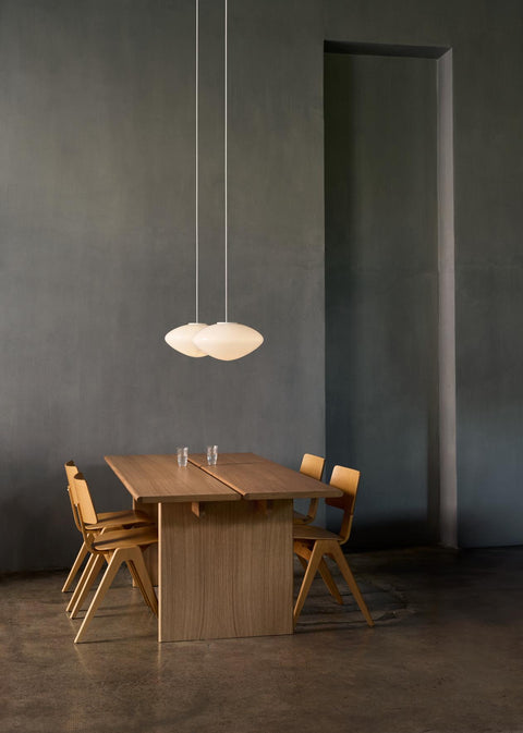 Daystak RD1 Side Chairs by &Tradition arranged around a minimalist oak dining table with pendant lights