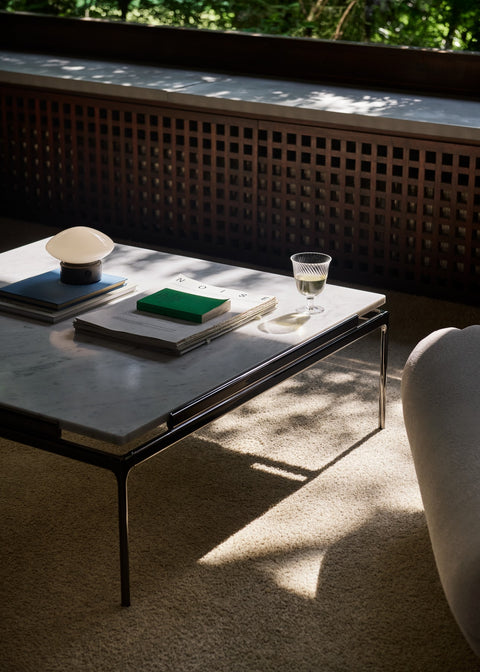 Sett LN13 Coffee Table in Bianco Carrara Marble by &Tradition styled with the Mist Table Lamp on beige carpet in a sunlit interior