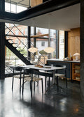 Contemporary dining space with Betty TK1 Side Chairs by &Tradition in black oak around dark dining table with large windows