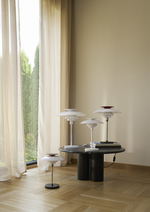 Collection of PH-80 Table Lamps in white and chrome displayed together in bright living space