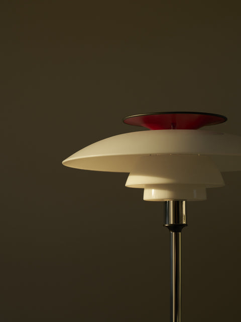 Close-up of PH 80 Portable Lamp in chrome finish highlighting red top reflector and layered shade design