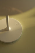 Detail view of PH 80 Portable Lamp in white finish showing circular touch control on base under soft light