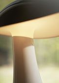 Close-up view of the Rumee 220 Portable Lamp’s illuminated shade highlighting its smooth finish and seamless design.