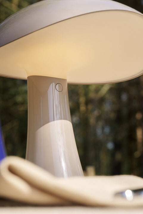 Close-up of the Rumee 220 Portable Lamp showing the touch dimmer and gentle light reflection outdoors.