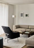 Fredericia A Chair by Jens Risom in dark patterned upholstery with brushed steel base in a modern Scandinavian living room
