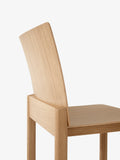 Close-up of Allwood AV35 Dining Chair by &Tradition showing curved oak backrest and precise joinery