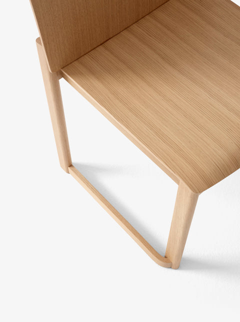 Detail of Allwood AV35 Dining Chair by &Tradition showing smooth oak grain and elegant seat profile