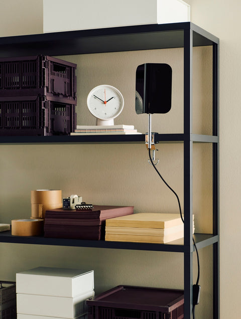 HAY Table Clock, White, white table clock, on a black shelving system with dark storage crates, wood boxes and a black clip lamp