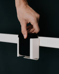 Pedestal Apple TV Mount in Pearl, steel Apple TV bracket, a hand fitting the mount onto a stand bar