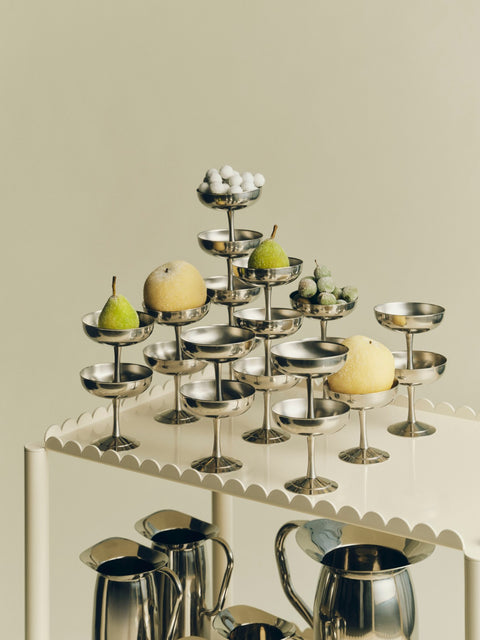 HAY Italian Ice Cup, Stainless Steel, stainless steel ice cream cup, many cups holding pears and lemons on a cream scalloped trolley