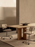 Audo Copenhagen Co Task Chair, Fully Upholstered, Without Arms, light oak Androgyne Dining Table with a black Releve Platter, flanked by two upholstered Co Task Chairs on a beige rug