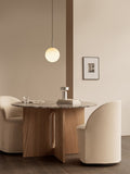Audo Copenhagen Tearoom Swivel Chair, With Loose Cover, cream Tearoom Club Chairs at the Androgyne Dining Table. A TR Bulb Pendant hangs above the grey marble tabletop