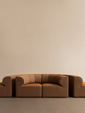 Audo Copenhagen Eave Seamline Modular Sofa, Rounded Modules, 34" Depth, Eave Seamline Modular Sofa, 86, Concave, Corner in a tan fabric, shown from the front against a simple, beige background
