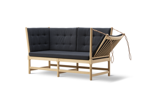 Three quarter angle of Fredericia Spokeback Sofa highlighting adjustable spoke back leather ties and oak spindle frame Danish design by Borge Mogensen