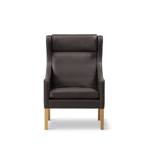 Front view of Borge Mogensen Wing Chair in dark brown leather with high back and cushion, oak legs, modern Scandinavian furniture, Canada
