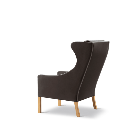Rear angled view of Mogensen Wing Chair showing curved profile, dark brown leather and oak legs, Fredericia Scandinavian furniture, Canada