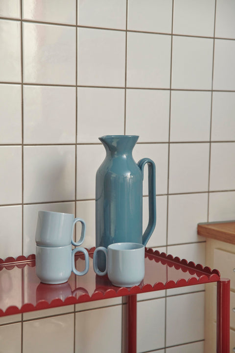 HAY Barro Cups, Light Blue, terracotta cups, two pale blue cups on a red trolley with a teal jug against a white tiled wall
