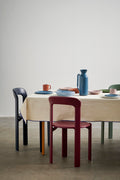 HAY Barro Bowls, Natural, glazed terracotta tableware, set on a cream tablecloth with a blue jug and painted wooden chairs