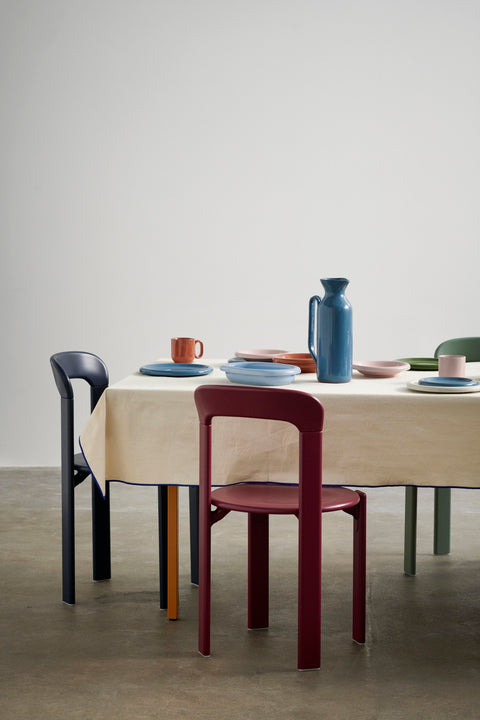 HAY Barro Bowls, Natural, glazed terracotta tableware, set on a cream tablecloth with a blue jug and painted wooden chairs