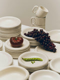 HAY Barro Cups, Off-White, terracotta cups, two cream cups on stacks of matching plates and bowls with grapes, a tomato and peas