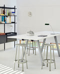 HAY Wall Clock, White, recycled ABS wall clock, mounted above black shelving in a bright room with a white high table and grey stools