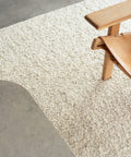 white boucle area rug and Spanish lounge chair