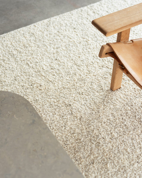 white boucle area rug and Spanish lounge chair