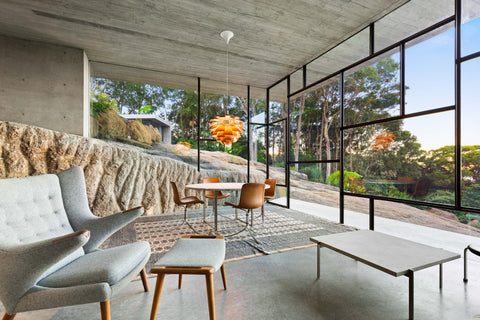 Copper Louis Poulsen PH Artichoke pendant over a round dining table in a glass walled modern home
