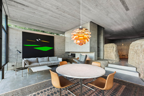 Copper Louis Poulsen PH Artichoke pendant lighting a concrete living and dining space with leather chairs and lounge seating