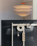 Pedestal Cable Bagel in Pearl, mounted behind a screen on a stand crossbar with a power bar below